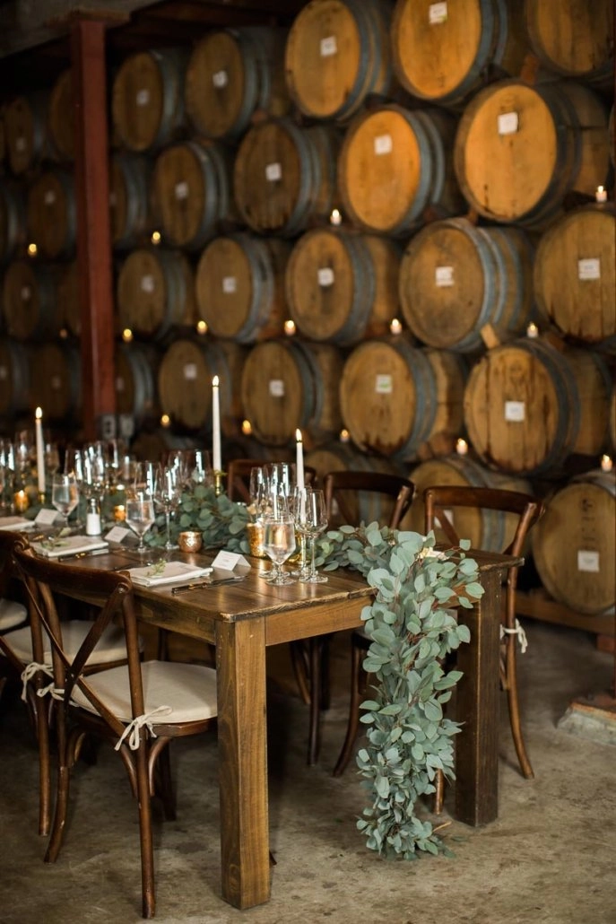 Wine barrel room dinner with eucalyptus runner