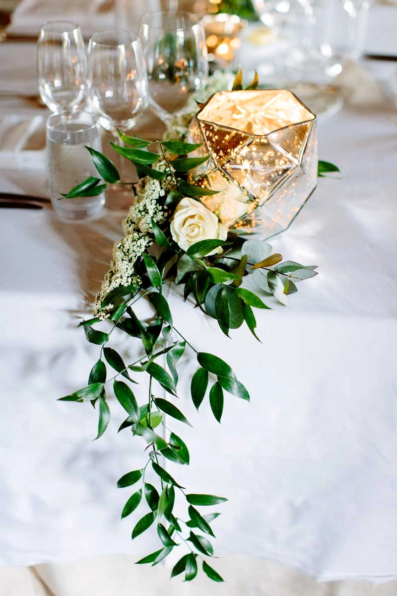 Mercury glass votive with white roses and trailing italian ruscus