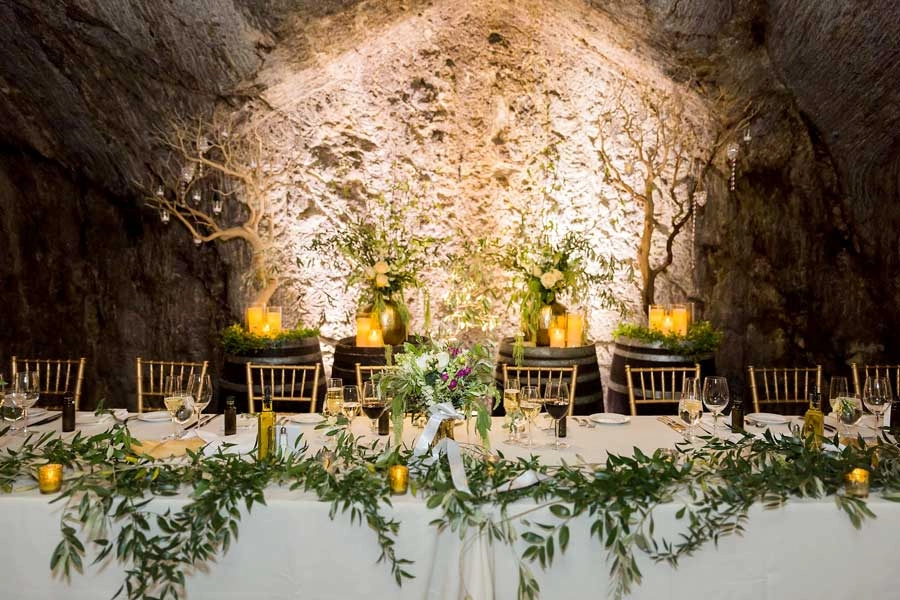 Wine cave head table with olive garland and candlelight