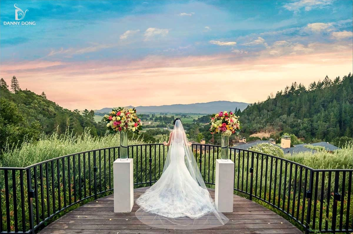 Bride at a Napa vista at sunset between pedestal arrangements