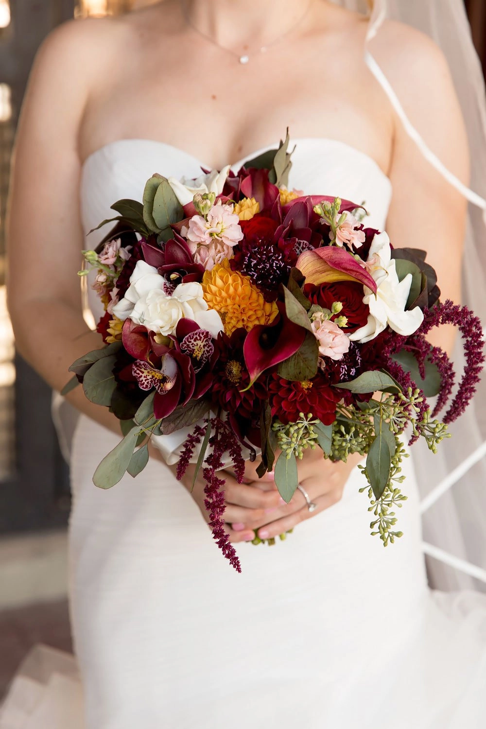 Autumn bridal bouquet of bordeaux orchids, dahlias and amaranthus